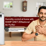 Happy Indian man breathing fresh air at home with SHARP QNET ZENsational air purifier in the frame