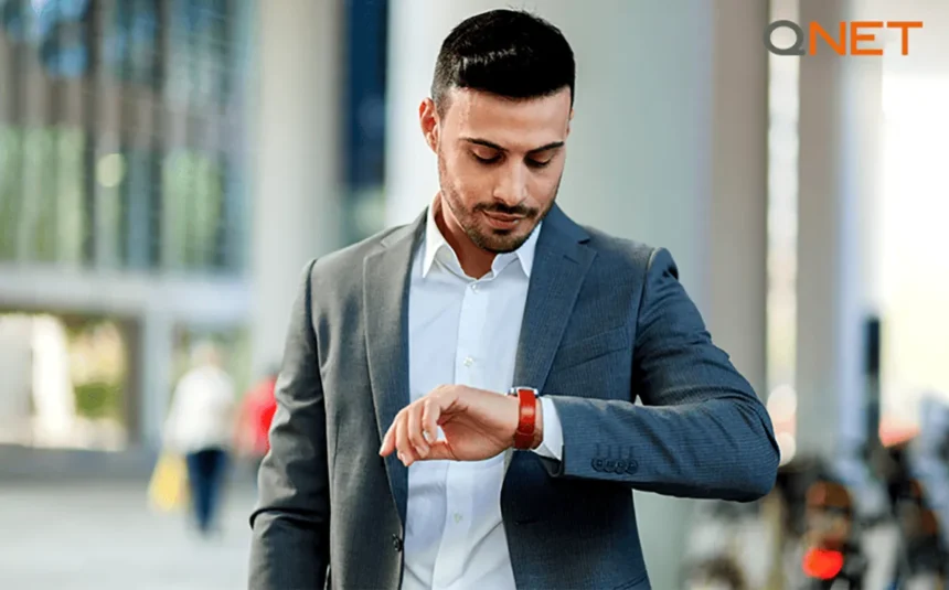 A young man looking at his wrist watch for time
