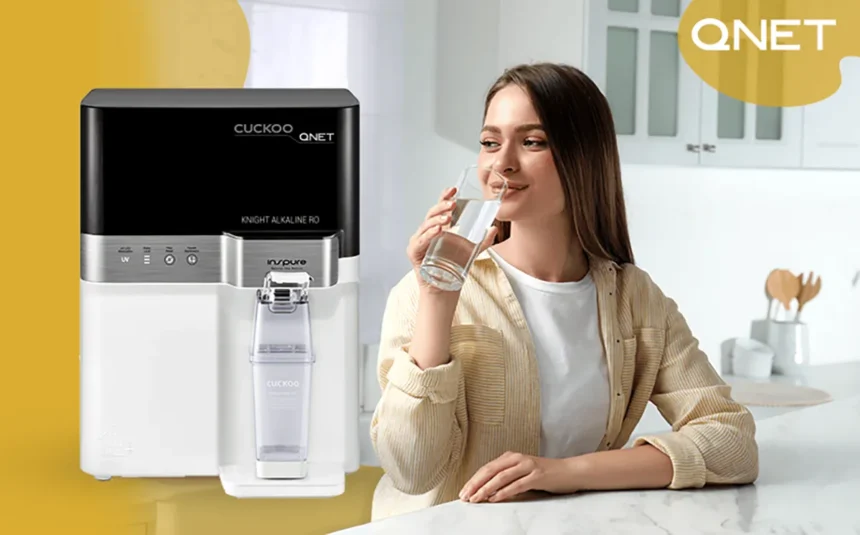 A young lady drinking water from Cuckoo water purifier