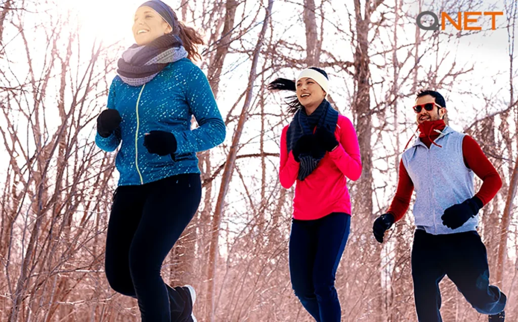 A couple jogging in the park wearing sweaters