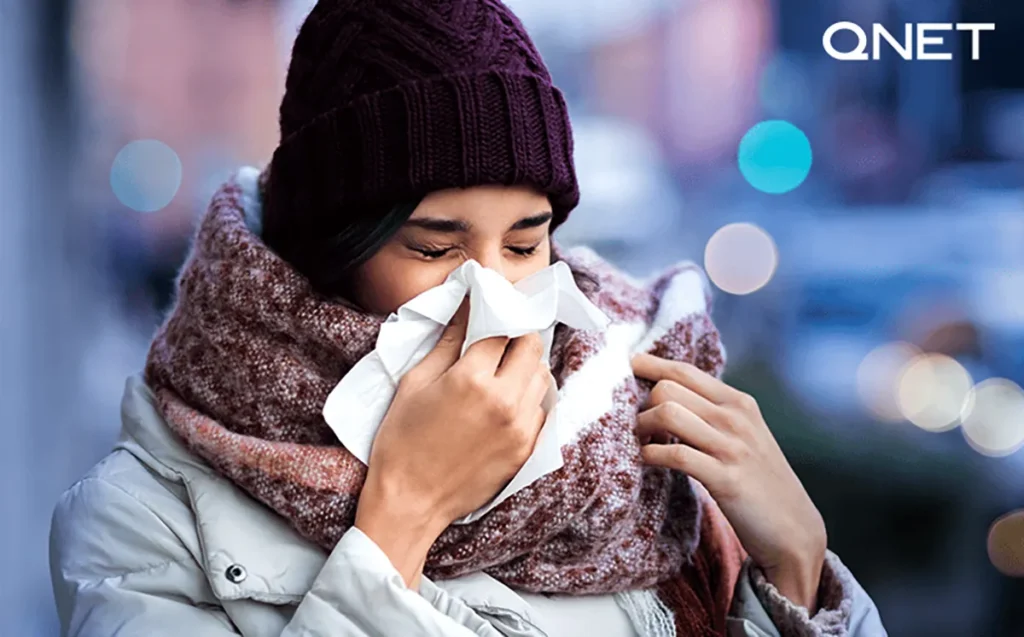 A girl sneezing with a handkerchief covering her nose