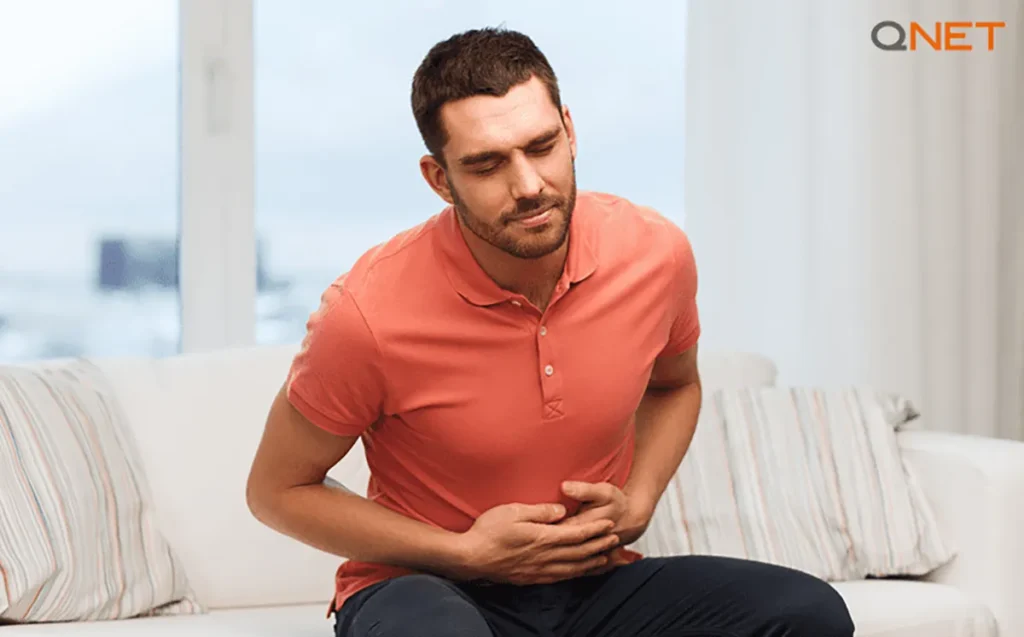 A young man experiencing digestive problems due to unhealthy lifestyle choices