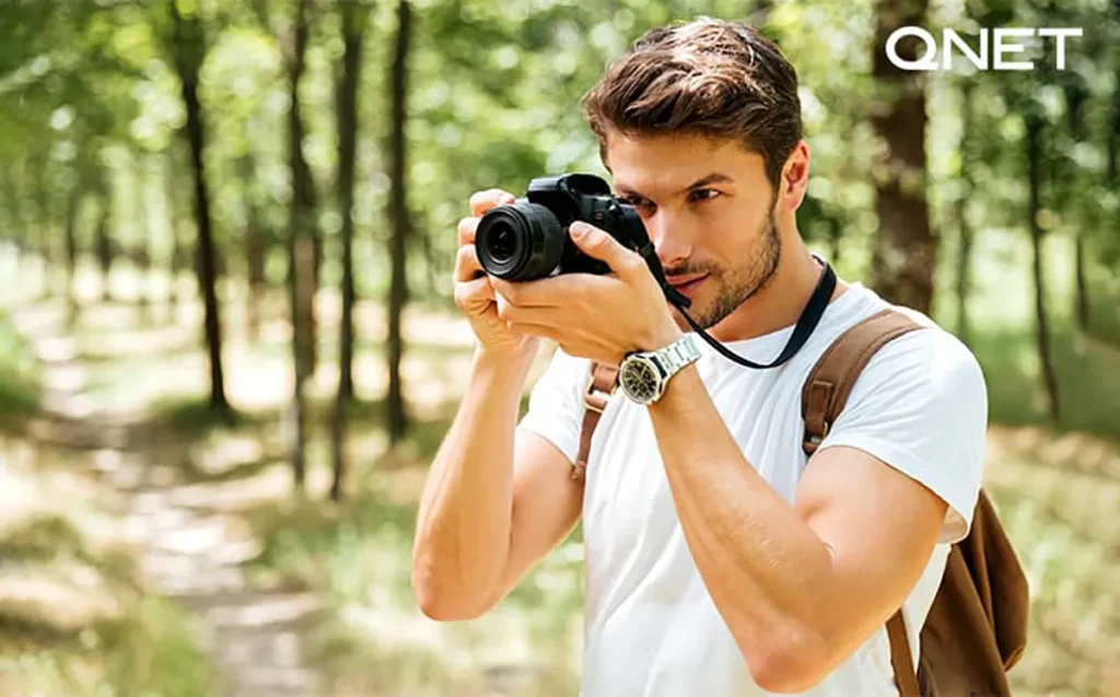 A young man taking a picture on his DSLR