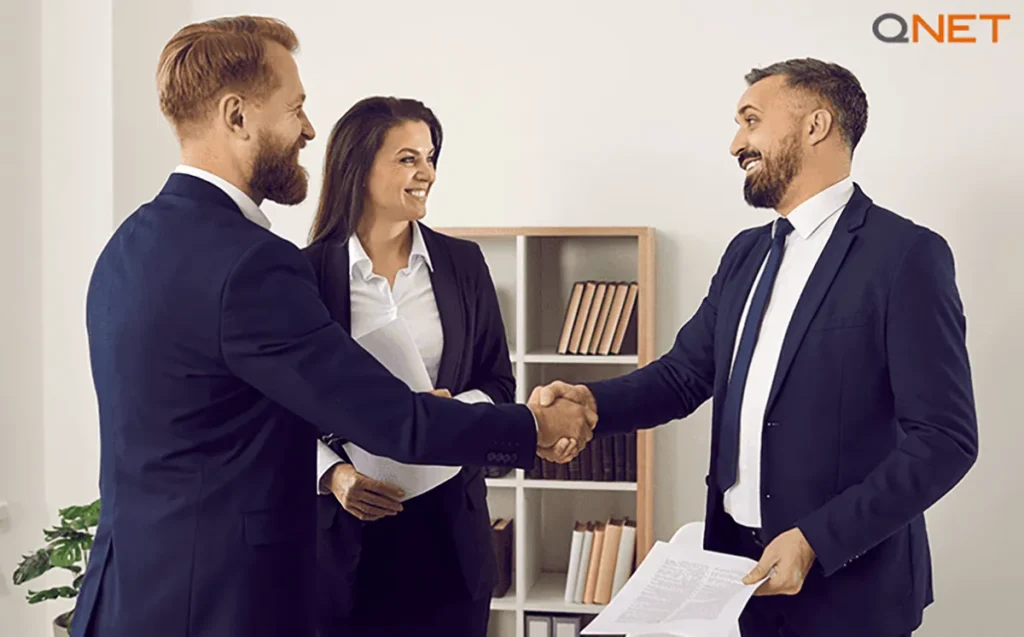 A businessman shaking hands with his clients – QNET India