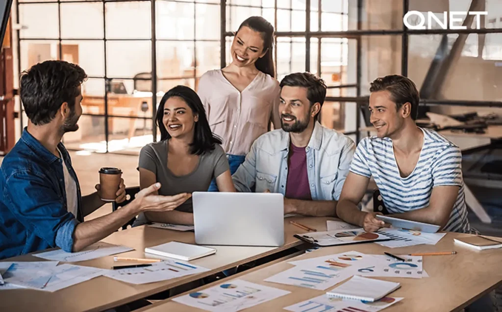 A Happy Leader Discussing Ideas with Colleagues | QNET India