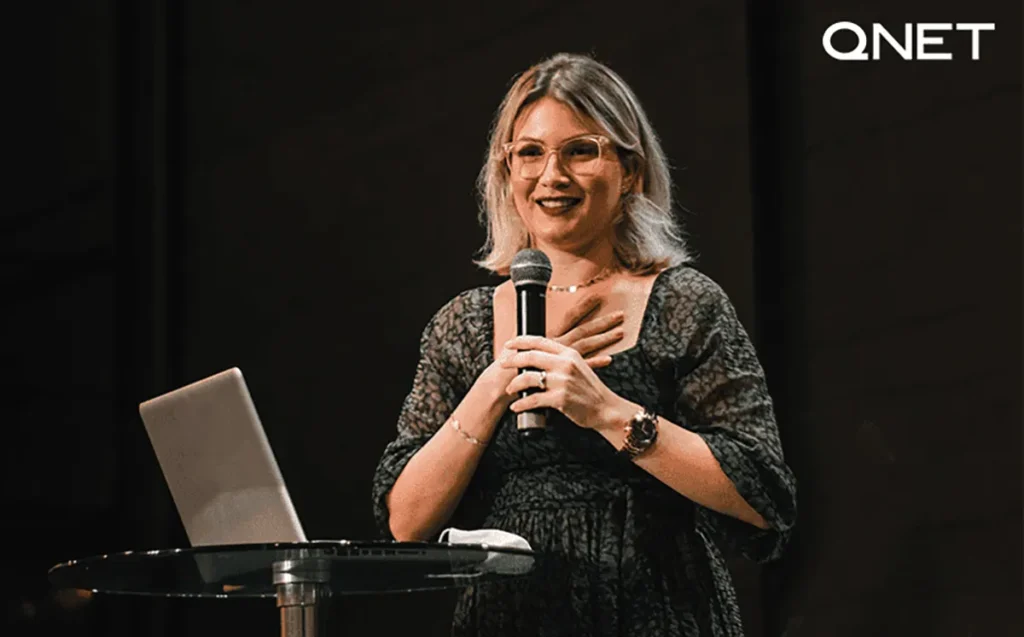 A successful young woman giving a speech on stage