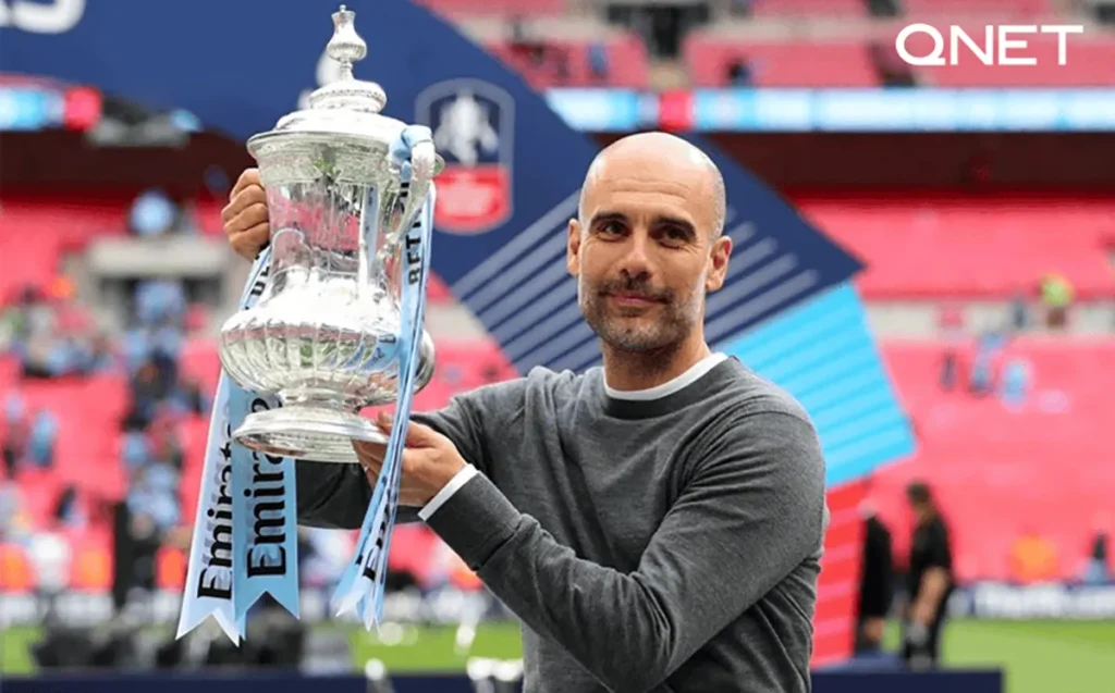 Pep Guardiola holding trophy