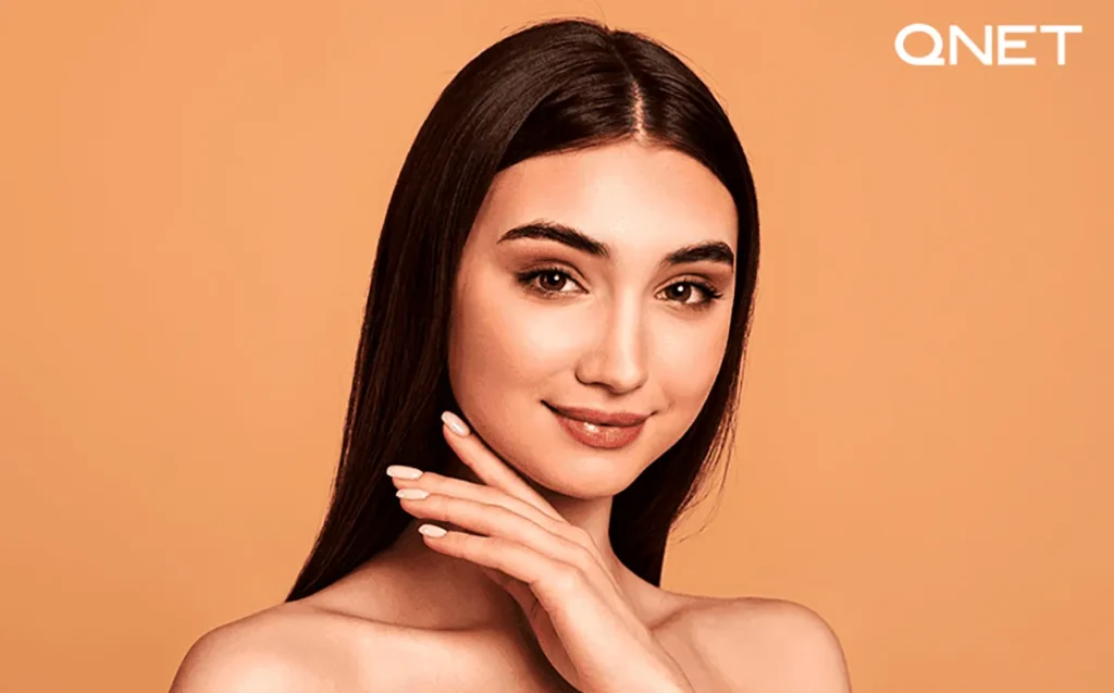 A close-up of a woman's face with dewy skin