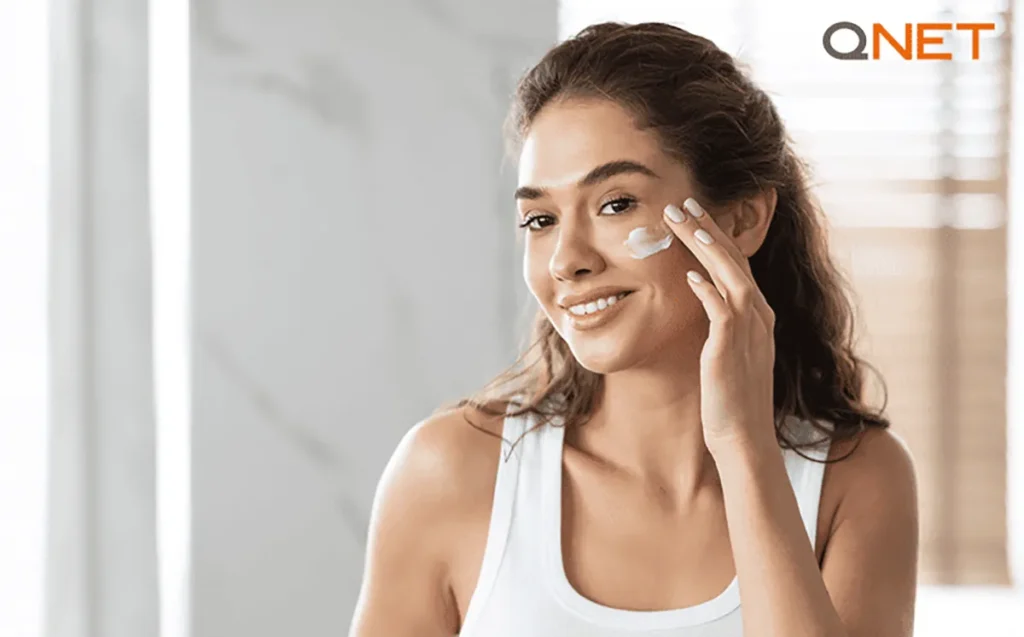 A woman applying moisturiser on her face