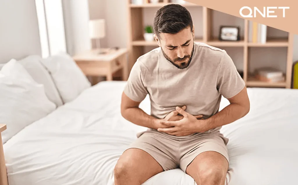 Man suffering from stomachache while lying on the sofa at home