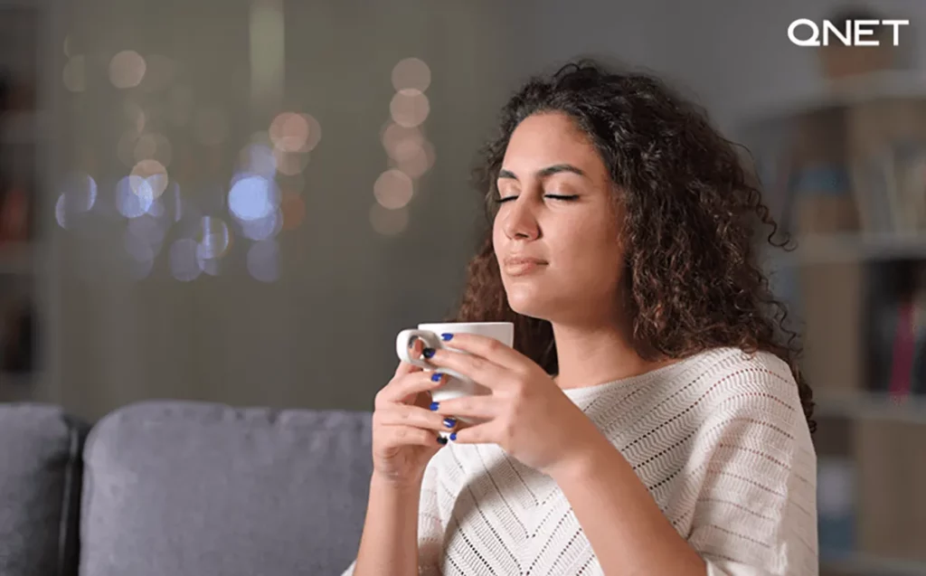 A young Indian woman drinking Nutrplus Qafe indoors showing us how to use green coffee for weight loss and health benefits