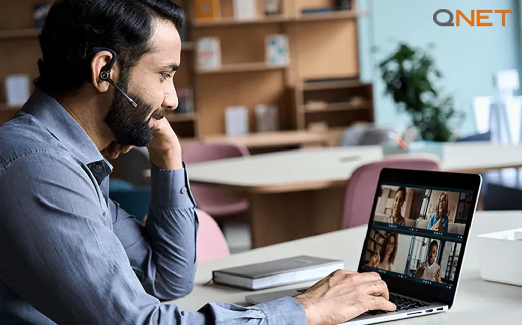 An Indian man working on a laptop during a zoom call interaction as a QNET direct seller