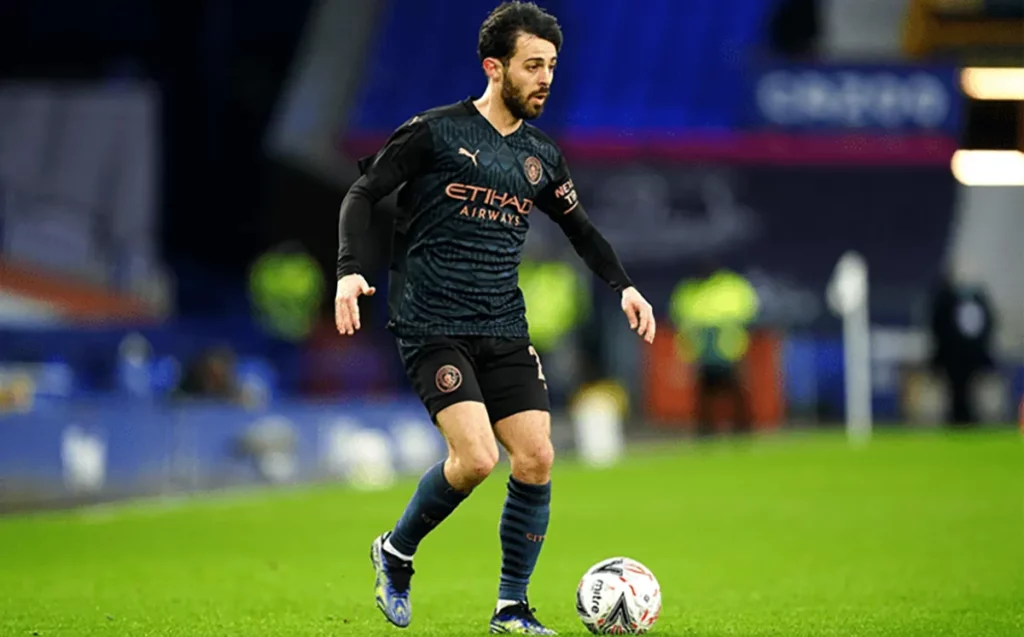 Manchester City player Bernardo Silva dribbling the ball.
