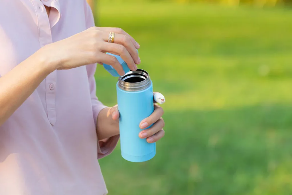 Drinking Water: Girl opens the cap of a water bottle